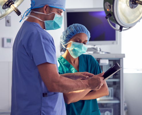 Side view of two healthcare professionals looking at a tablet