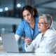 Two medical professionals looking at information on laptop